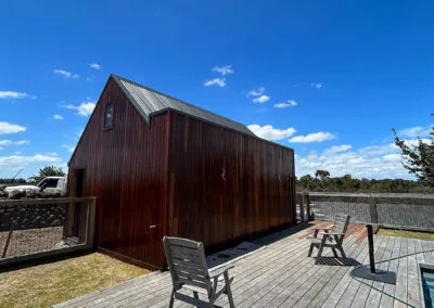 Hardwood deck and seating beside a timber-clad cabin
