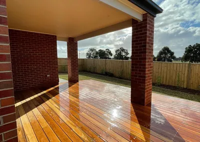 Hardwood deck under a covered alfresco with brick posts