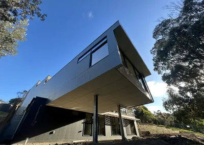 Timber-clad upper storey and balcony on a sloping block