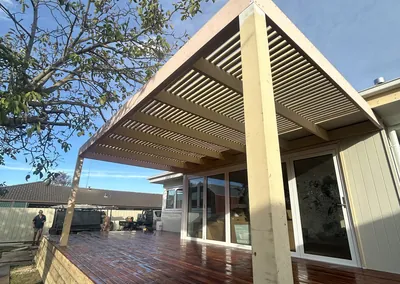 Corner of a timber slat pergola with a hardwood deck below