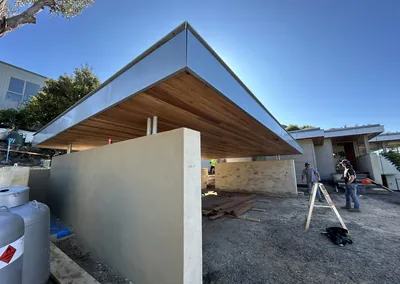 Timber-lined cantilever roof and rendered wall at an outdoor living area